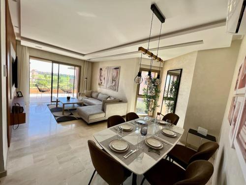 Una mesa de comedor y sillas en una sala de estar. en New appart, pool and golf view, en Marrakech