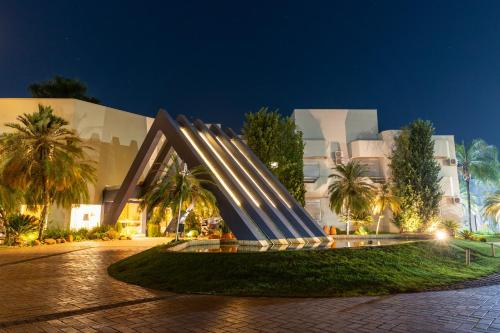 um edifício com uma escultura à sua frente à noite em Ucayali Hotel em Sinop