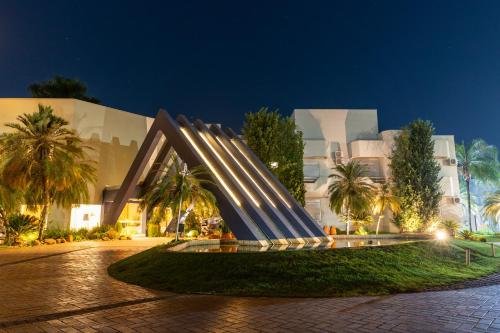 a building with a sculpture in front of it at night at Ucayali Hotel in Sinop