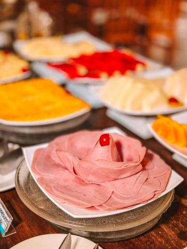 a table topped with plates filled with different types of food at Canzi Cataratas Hotel in Foz do Iguaçu
