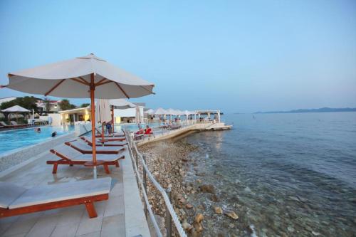 - une plage avec des chaises et un parasol à côté de l'eau dans l'établissement Villa Anabella II, à Zadar