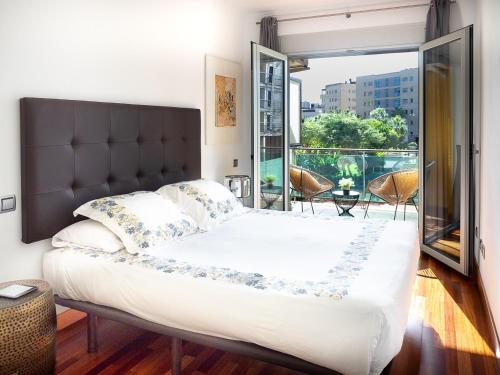 sypialnia z dużym łóżkiem i balkonem w obiekcie Apartment Abora Garden with terrace, pool, extensive gardens and free parking w mieście Las Palmas de Gran Canaria