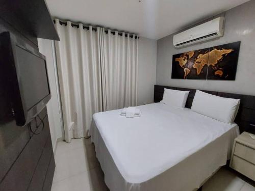 a bedroom with a white bed and a flat screen tv at Brisas do Lago Diária Brasil 67961 in Brasilia