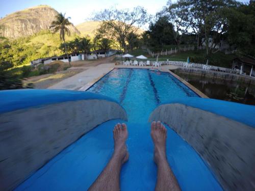 a man laying on the edge of a swimming pool at Apt quarto 228 - hotel pedra Rodeadouro-Bonito-PE in Bonito