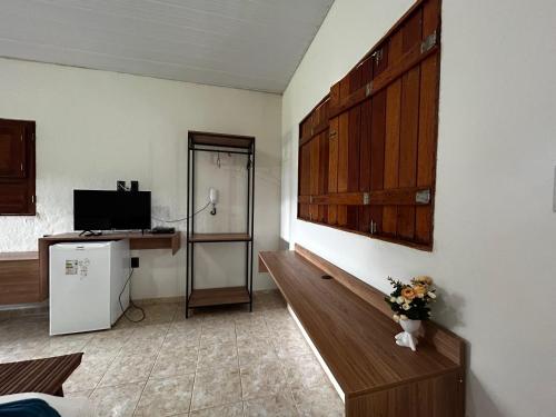 Apt quarto 228 - hotel pedra Rodeadouro-Bonito-PE في بونيتو: غرفة بها مكتب وتلفزيون في غرفة
