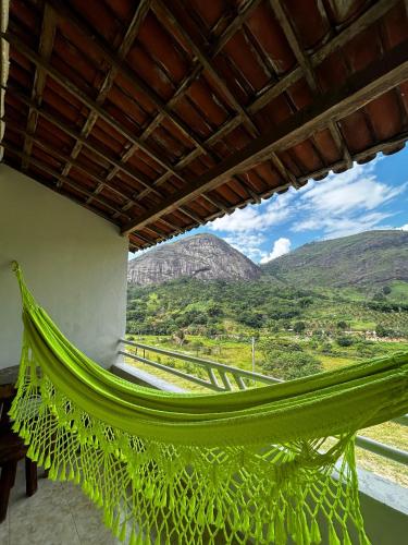 a hammock in a room with mountains in the background at FLAT 228 - Hotel Pedra do Rodeadouro-Bonito-PE in Bonito