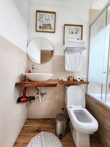 a bathroom with a sink and a toilet at Pousada Geada de Campos in Campos do Jordão