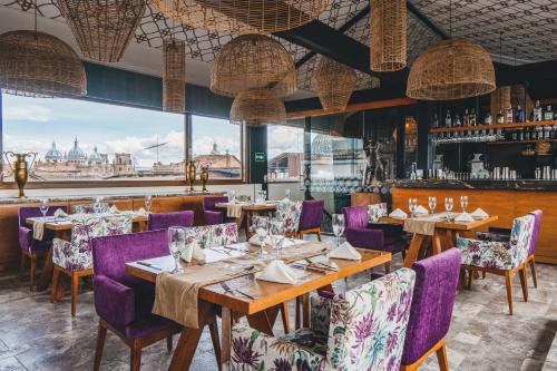 a restaurant with wooden tables and purple chairs at Hotel Cruz del Vado in Cuenca