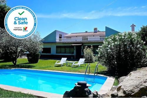 a person sitting in front of a swimming pool at Casa do Vale-Villa with private pool and garden in Palmela