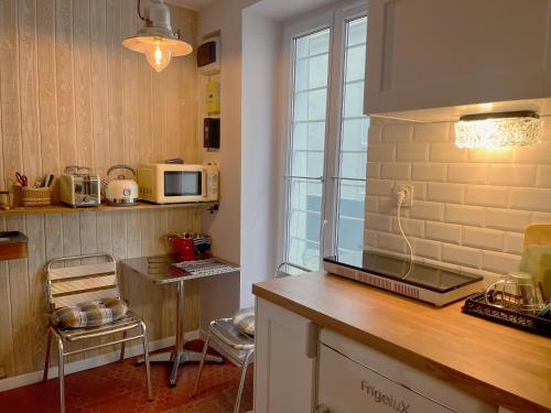 - une cuisine avec un comptoir et un four micro-ondes dans l'établissement Charmant 2 pièces Paris Montmartre, à Paris