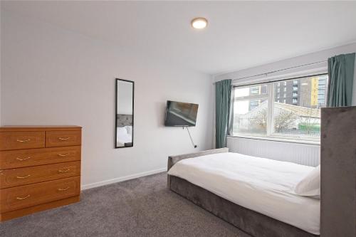 sypialnia z łóżkiem, komodą i oknem w obiekcie EDSPACE w mieście Abbey Wood