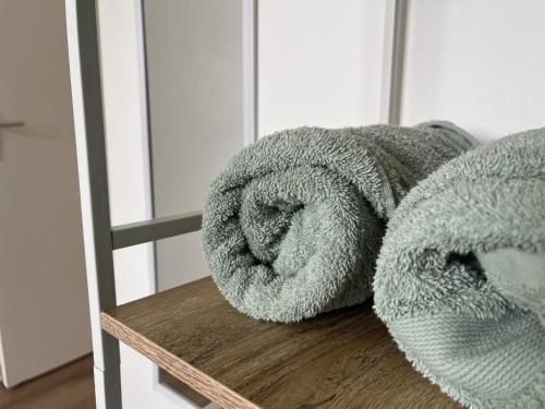 un par de toallas sentadas en un banco de madera en Good vibes Only apparts "So Zen" - 3 bedrooms - 8 pers - 20mn to Paris en Enghien-les-Bains