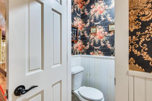 a bathroom with a toilet and a floral wallpaper at Smethport Vacation Rental with Fireplace and Lake View 