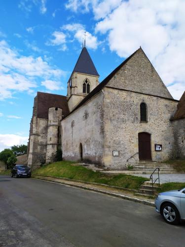 eine alte Kirche mit einem Turm und einem Auto auf der Straße in der Unterkunft la Grange de Chérence in Chérence