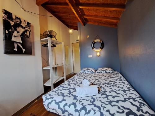 a bedroom with a bed with a blue and white comforter at Sardines and Friends Hostel 04 in Póvoa de Varzim