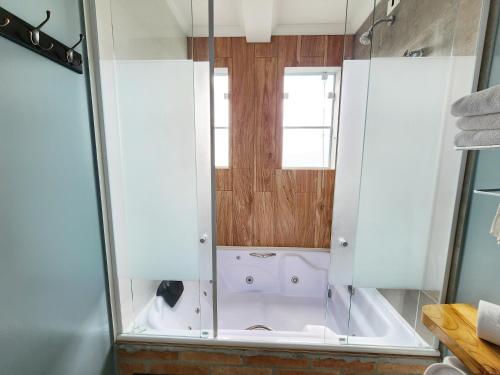 a shower with a glass door in a bathroom at Pousada Geada de Campos in Campos do Jordão