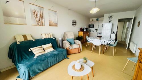 un salon avec un canapé et une table dans l'établissement Les océanides, T2 face océan, à Notre-Dame-de-Monts