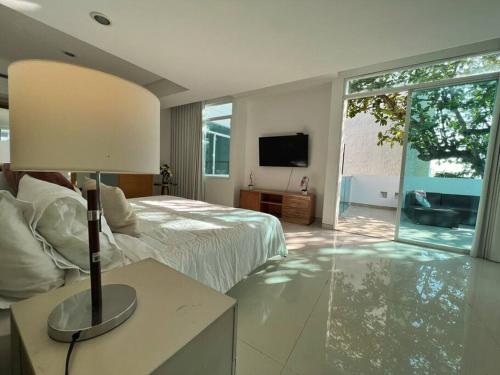 ein großes Schlafzimmer mit einem Bett und einem TV in der Unterkunft Lujosa Casa con jacuzzi CastilloGrande in Cartagena de Indias