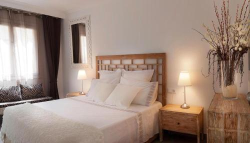 a bedroom with a white bed and two lamps at Con Encanto in Port de Soller