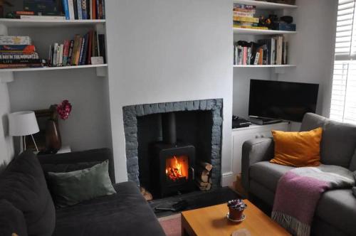 a living room with a fireplace and a couch at Lovely fisherman's cottage near beach and harbour in Whitstable