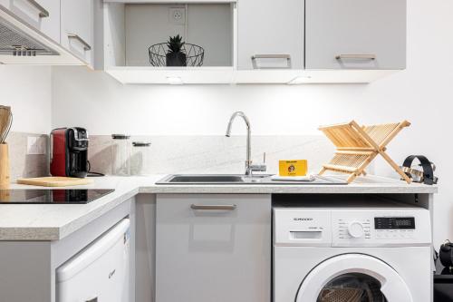 une cuisine avec une machine à laver et un évier dans l'établissement Charming City Center Studio 108, à Nice