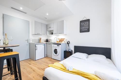 une chambre blanche avec un lit et une cuisine dans l'établissement Charming City Center Studio 108, à Nice