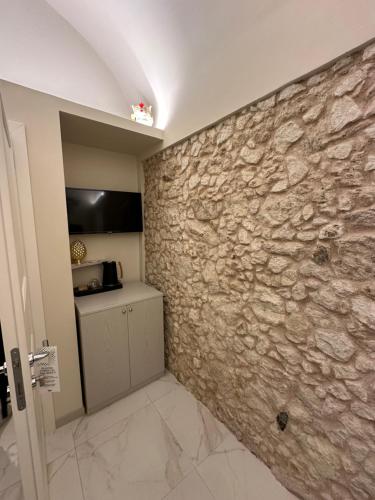 pared de piedra en una habitación con cocina en That's Amore Accommodation Tropea, en Tropea