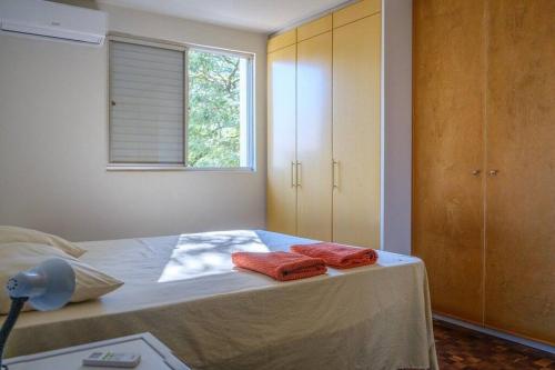 a bedroom with a bed with two red towels on it at Apartamento Suite mais 2 QTS Espaçoso Ar Cond SQ21 in Maringá