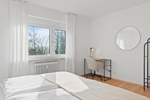 a white bedroom with a bed and a mirror at ☆Roomfall: Design Suite am Kurpark in Bad Rappenau