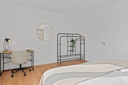 a bedroom with a bed and a desk and a mirror at Roomfall Apartment am Kurpark mit TG & Wifi & Balkon in Bad Rappenau