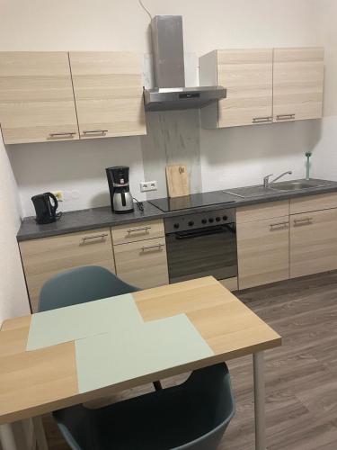 a kitchen with a wooden table and a counter top at Wohnung Villa Kasper EG in Goldenstedt