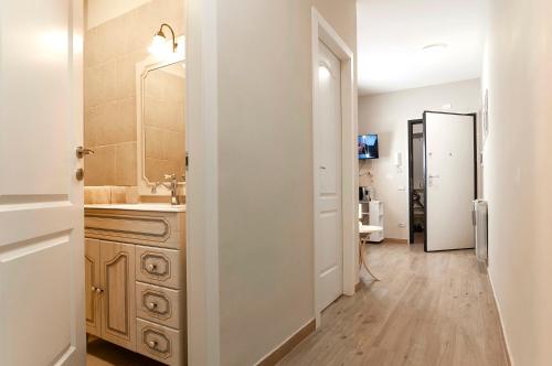 y baño con lavabo y espejo. en Elegant comfy three-room apartment in Eur with parking, en Roma