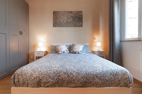 a bedroom with a large bed with two night stands at Elegant comfy three-room apartment in Eur with parking in Rome