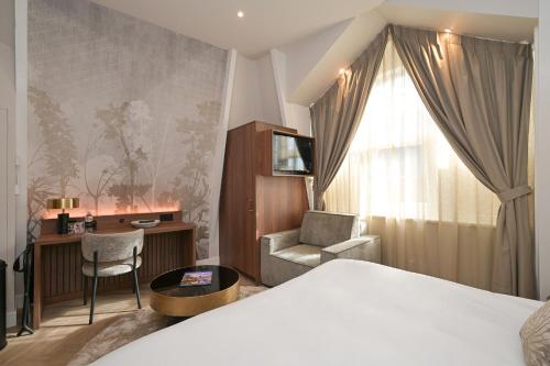 Habitación de hotel con cama, escritorio y silla en Novallure Downtown - Short Stay Apartments, en La Haya