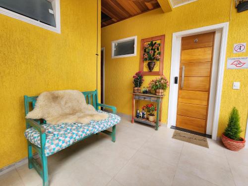a blue bench with a blanket on it in a room at Pousada Geada de Campos in Campos do Jordão