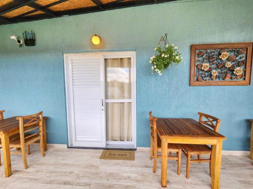 a room with a table and chairs and a door at Pousada Geada de Campos in Campos do Jordão