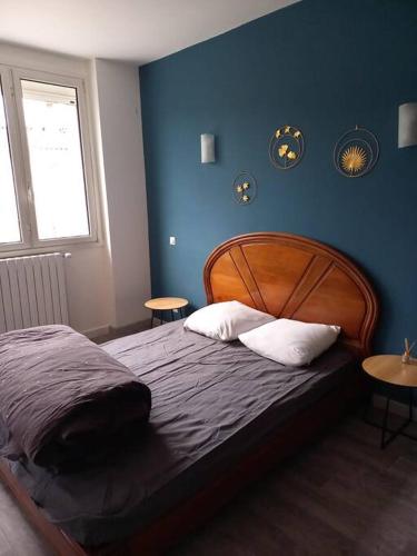 une chambre avec un lit avec un mur bleu dans l'établissement Grande Villa Ardèche, à Le Teil