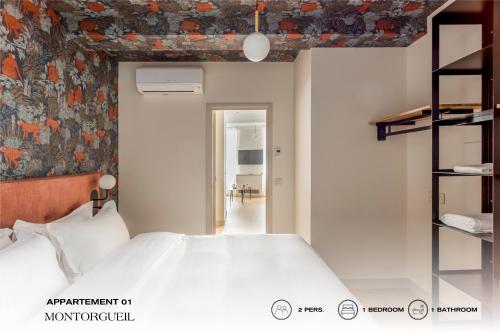 パリにあるBeauquartier - Montorgueilの花柄の壁紙を用いたベッドルーム1室(白い大型ベッド1台付)