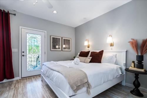 a white bedroom with a large bed and a window at Luxe Farmhouse ~ Hot Tub + Pool ~ Great4Gatherings in Manor