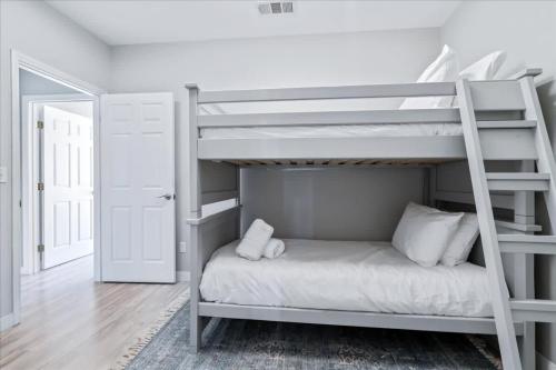 a bedroom with a bunk bed with a ladder at Luxe Farmhouse ~ Hot Tub + Pool ~ Great4Gatherings in Manor