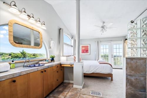 a bedroom with a bed and a sink and a bathroom at Luxe Farmhouse ~ Hot Tub + Pool ~ Great4Gatherings in Manor