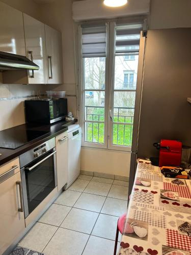 une cuisine avec une table et une fenêtre. dans l'établissement sweet appartement Disneyland Paris parking 300m station val d'Europe, à Chessy