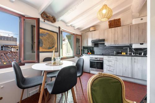 une cuisine avec une table et des chaises dans une pièce dans l'établissement Charming Apartment Old Town, à Nice