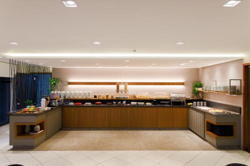 a restaurant with a counter with food on it at Realce Hotel in Jaú