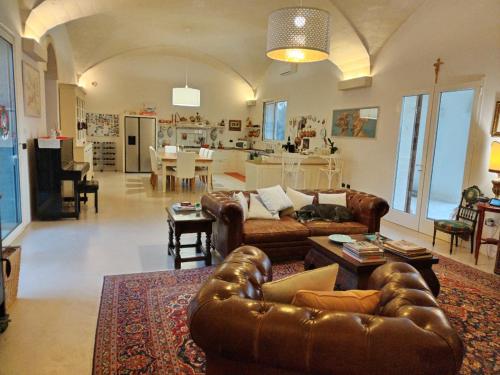 un soggiorno con divani in pelle e una cucina di relax di lusso in Salento a Torchiarolo
