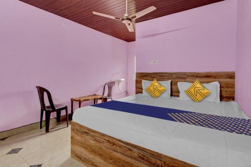 una camera con un grande letto e una sedia di OYO Hotel Lambacingi Grands a Lammasingi