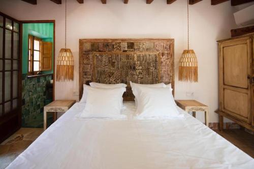 a bedroom with a large bed with white pillows at Camp de sa mar in Port de Soller