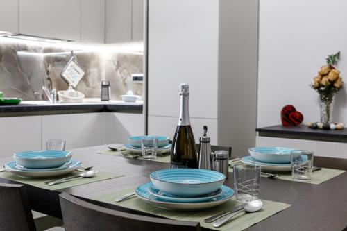 a table with blue plates and a bottle of wine at RESIDENCE MARCO POLO in Montesilvano
