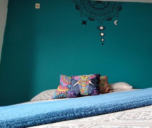 1 dormitorio azul con 1 cama con pared azul en Mandallah Hostel en Joinville