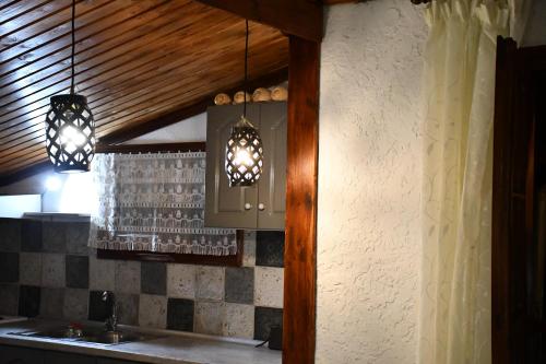 eine Küche mit zwei Lampen, die über einer Theke hängen in der Unterkunft Heliofos Apartments in Stomio